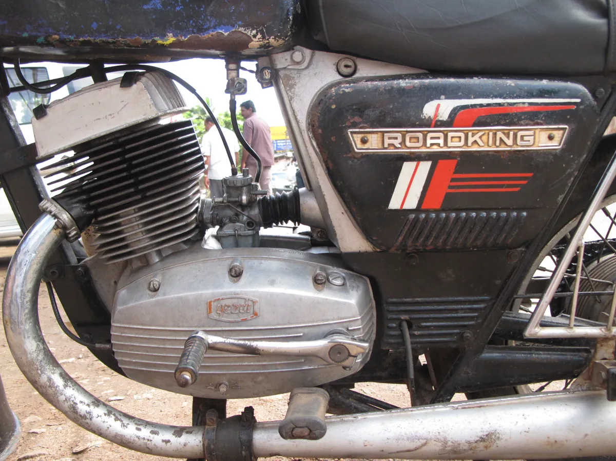 Motor de dos tiempos con el carburador visible en un taller